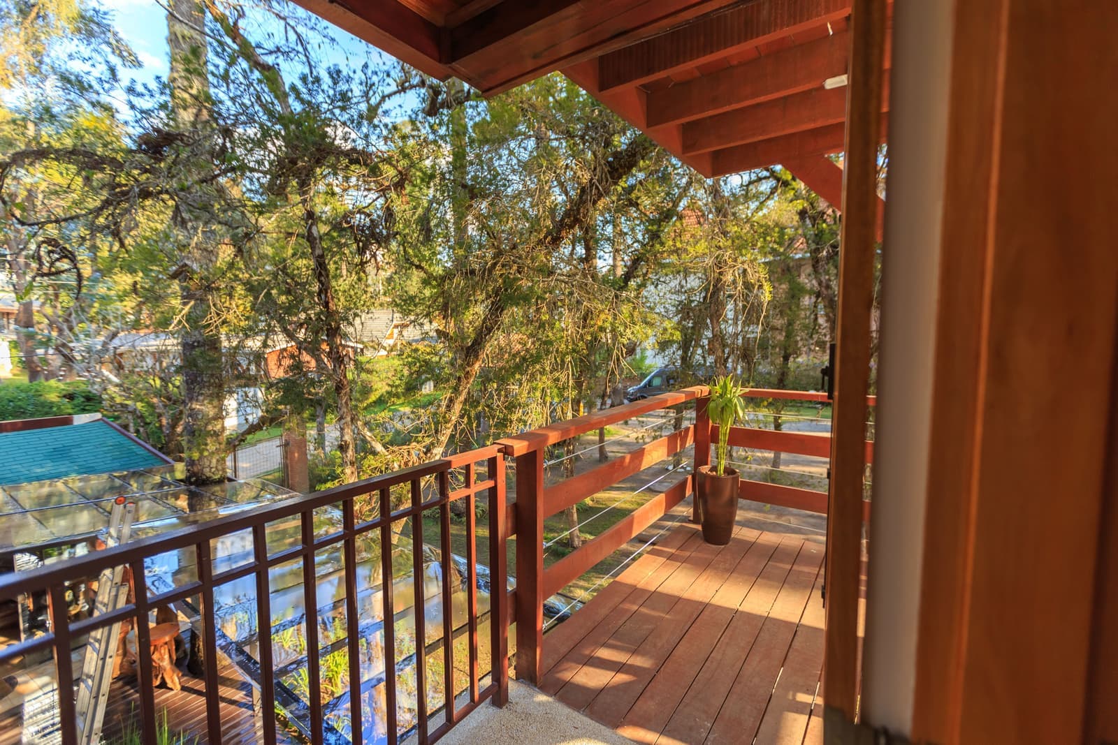 A wooden deck railing looking out over a garden