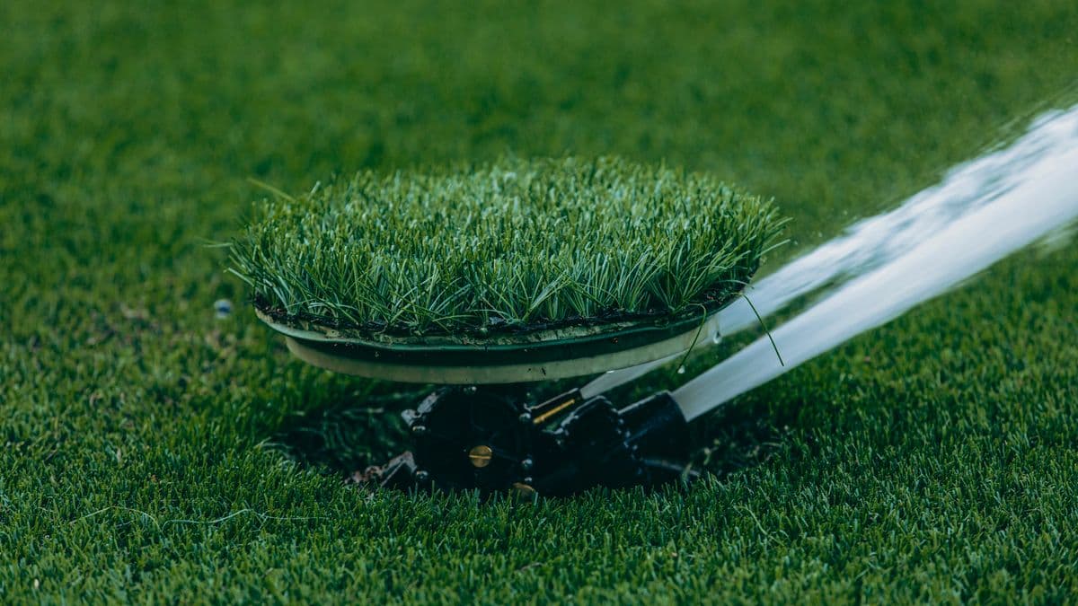 A lawn sprinkler spraying water across a green yard