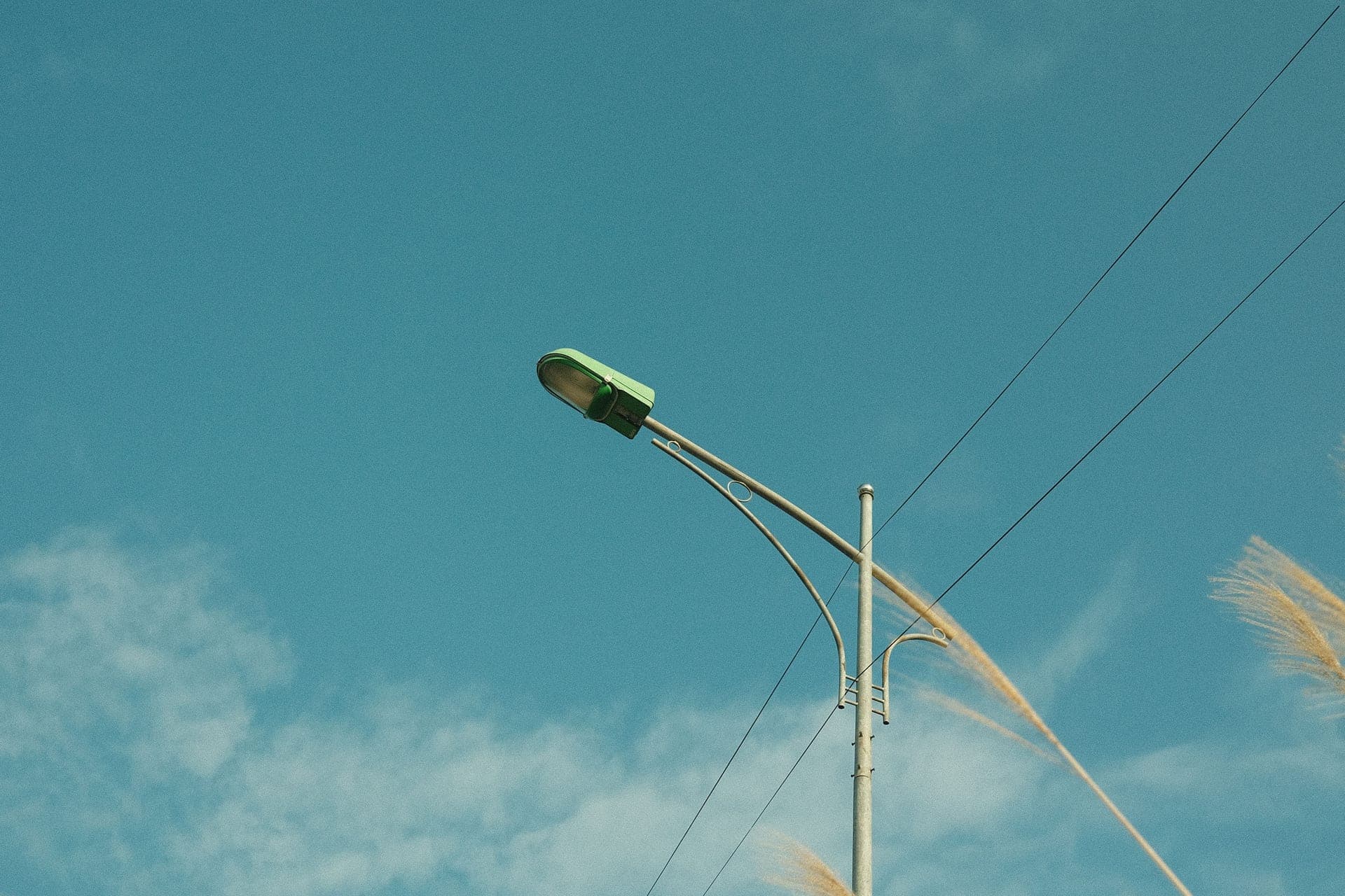 A bird feeder standing against a wide, pale sky
